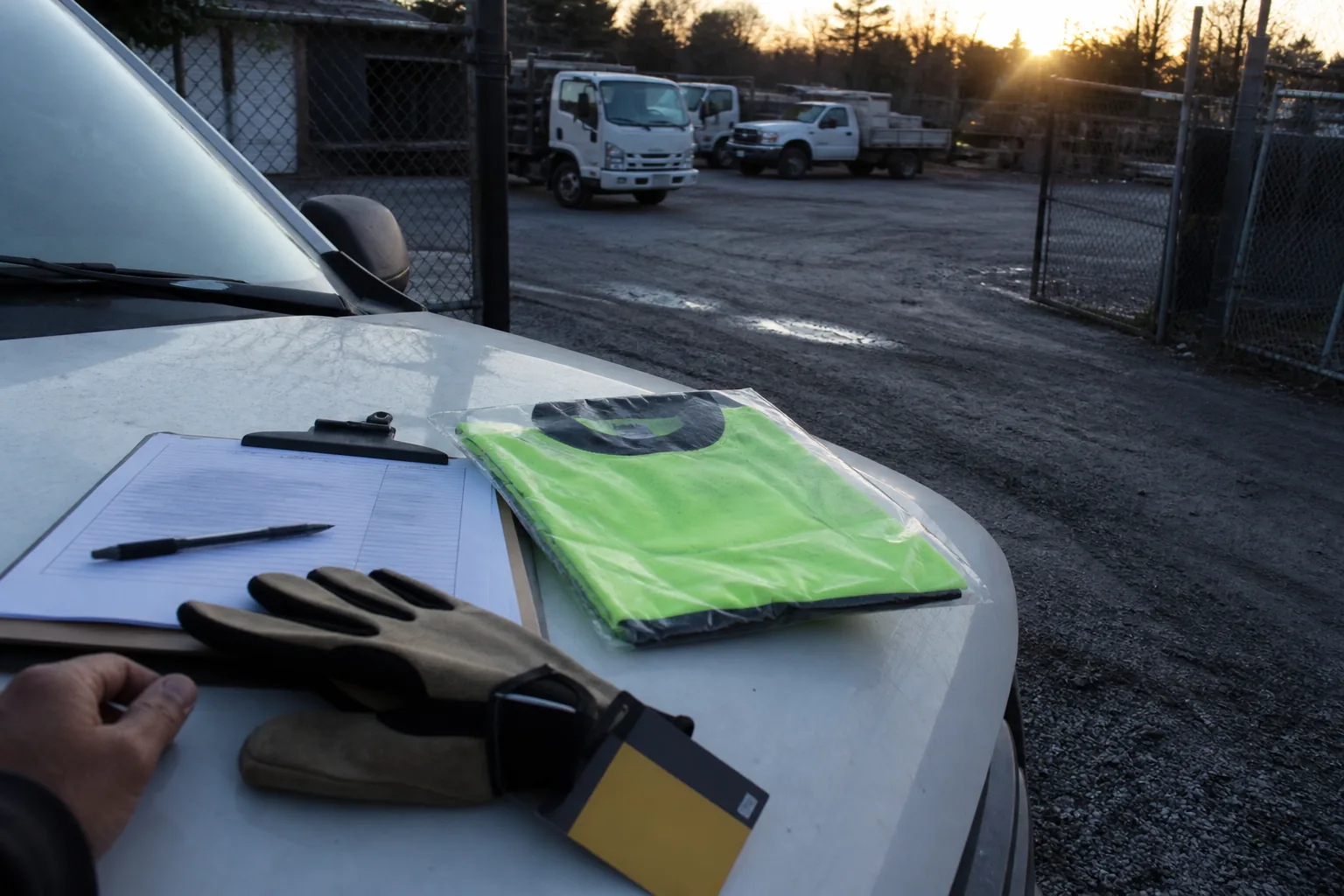 New safety gear and hiring paperwork set out beside an empty work yard